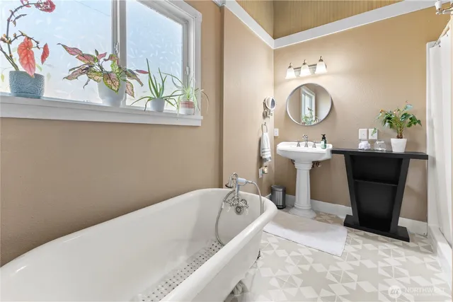 a bathroom with a bathtub sink and mirror