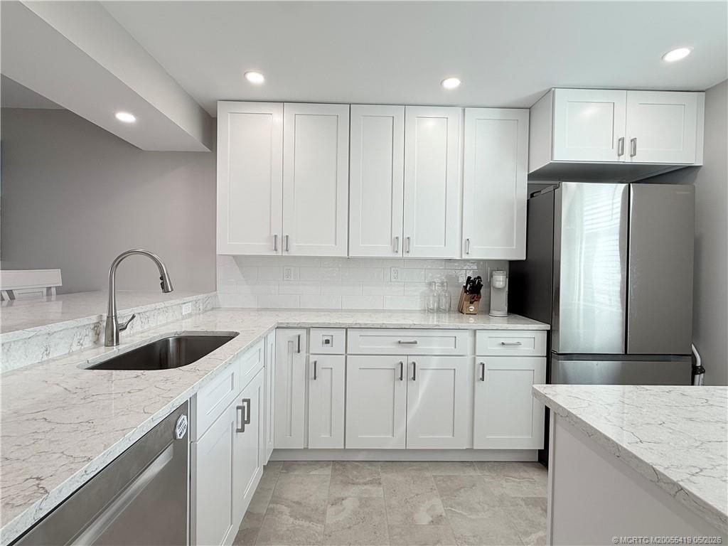 1950 Southwest Palm City Road, Unit 14305 Stuart, FL 34994 - Photo 27 of 70 a kitchen filled with white cabinets