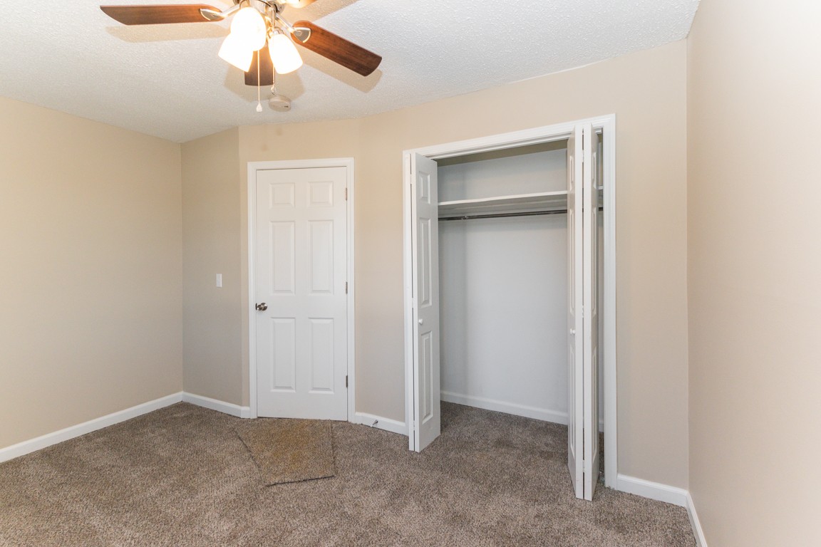 816 Garrettsburg Road Clarksville, TN 37042 - Photo 23 of 34 an empty room with a chandelier fan and closet area