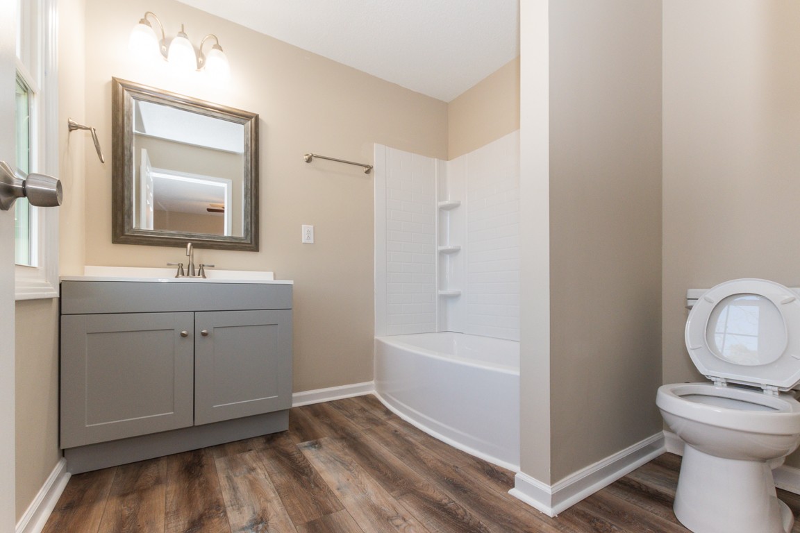 816 Garrettsburg Road Clarksville, TN 37042 - Photo 25 of 34 a bathroom with a toilet sink vanity tub and mirror
