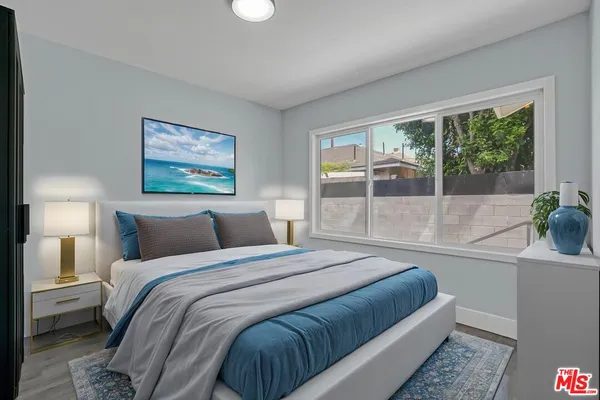 a bedroom with a bed and a large window