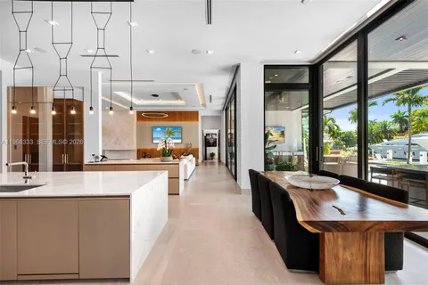 a dining room with furniture a floor to ceiling window and a potted plant