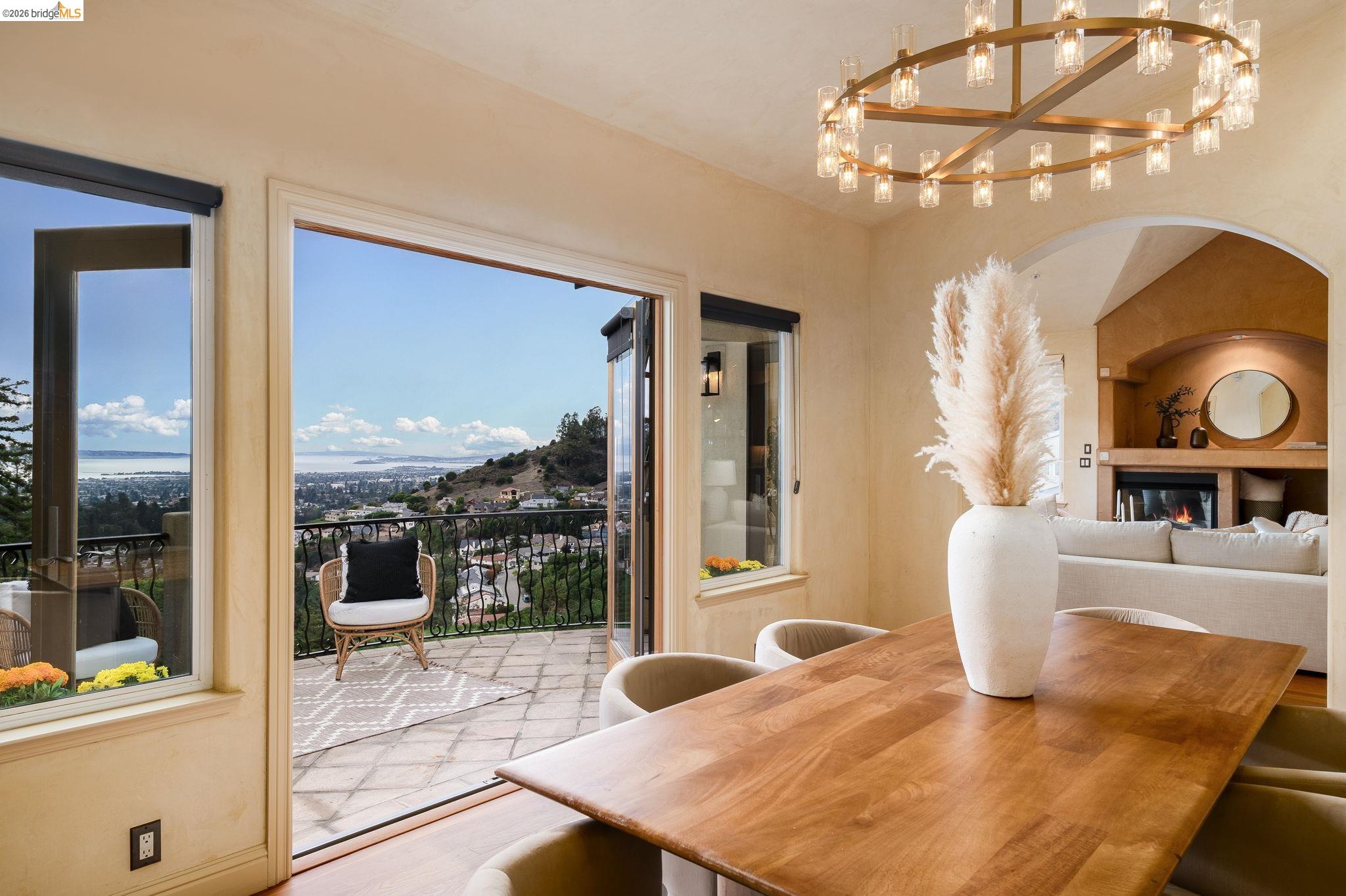 6257 Virgo Road Oakland, CA 94611 - Photo 14 of 60 Dining area featuring a glass covered fireplace, a chandelier, wood finished floors, and lofted ceiling