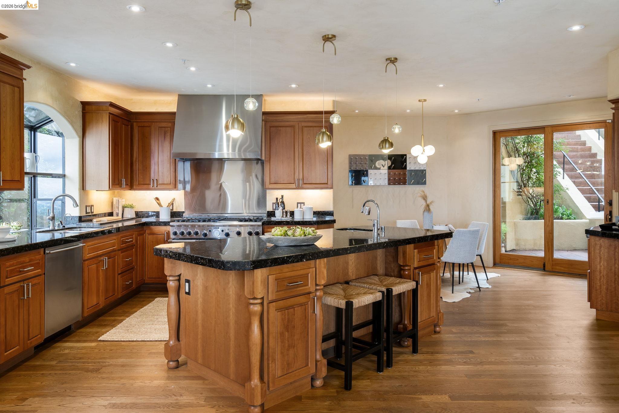 6257 Virgo Road Oakland, CA 94611 - Photo 23 of 60 Kitchen featuring plenty of natural light, a center island with sink, brown cabinetry, and recessed lighting