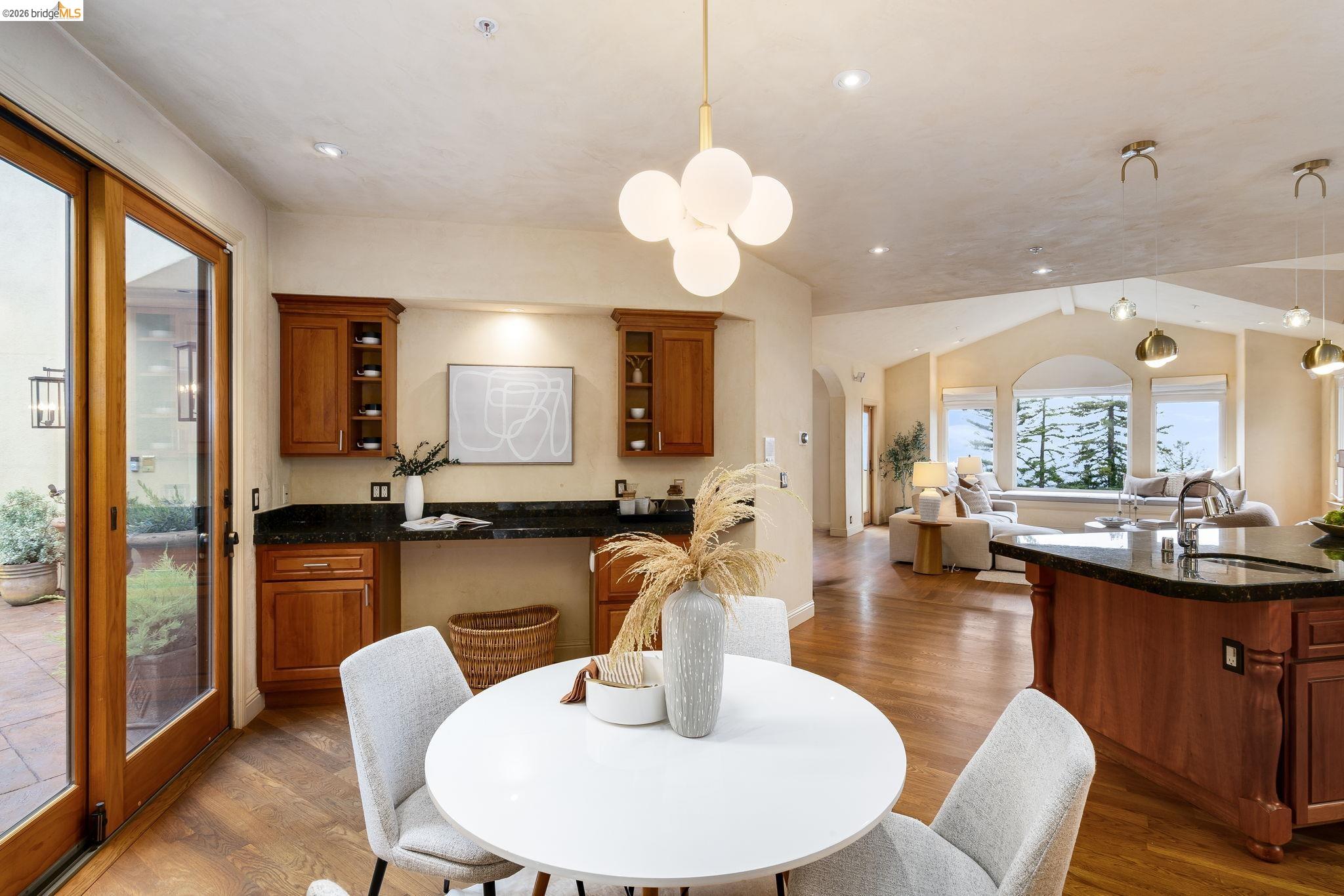 6257 Virgo Road Oakland, CA 94611 - Photo 26 of 60 a dining room with wooden floor a chandelier a glass table and chairs