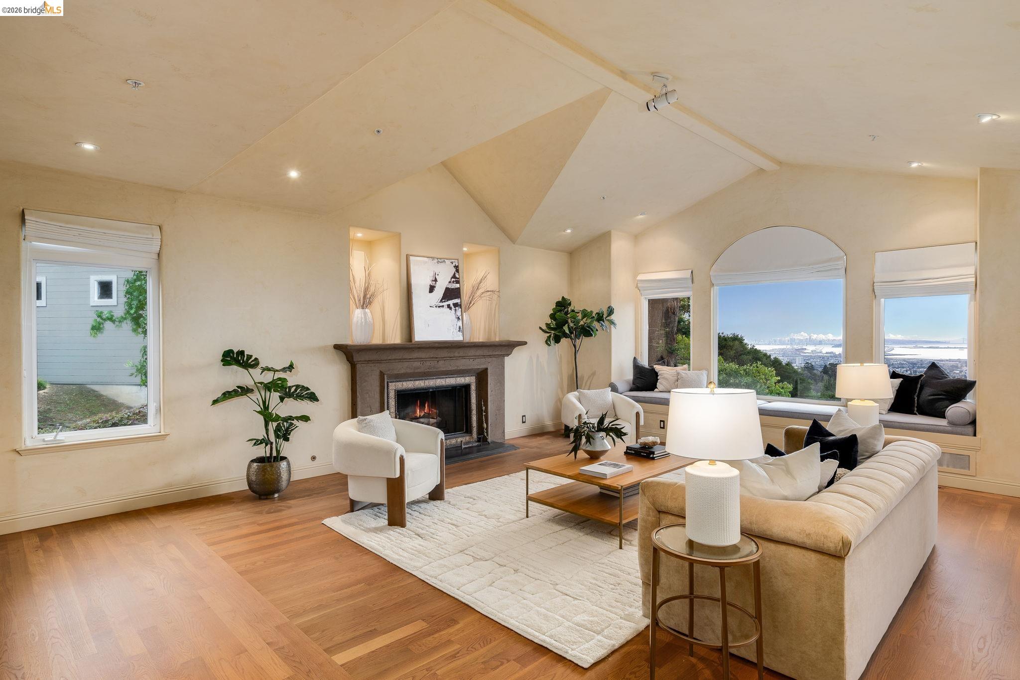 6257 Virgo Road Oakland, CA 94611 - Photo 28 of 60 Living room featuring a fireplace with flush hearth, healthy amount of natural light, light wood-style flooring, beamed ceiling, and high vaulted ceiling