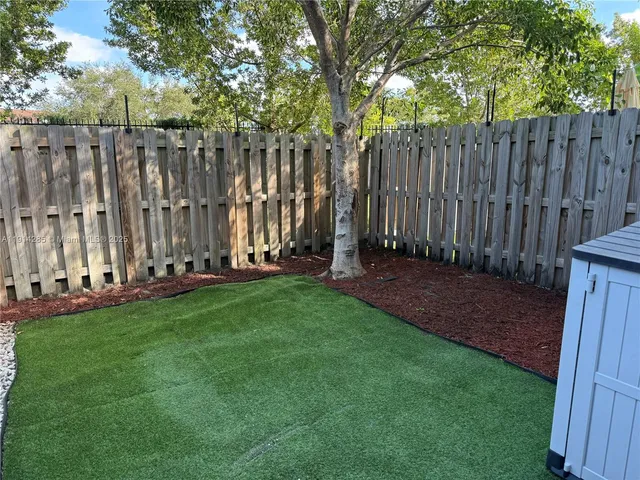 a view of a yard with wooden fences