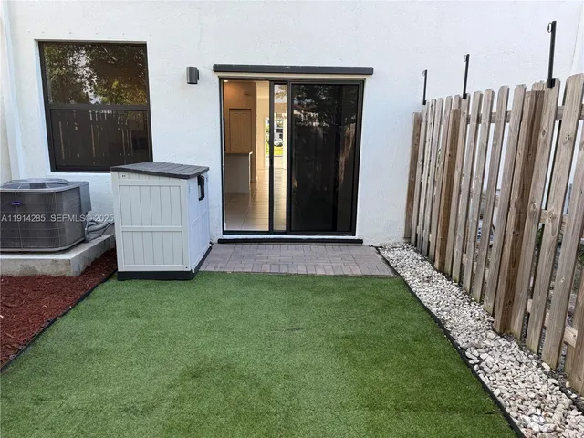 a view of a yard with wooden fence
