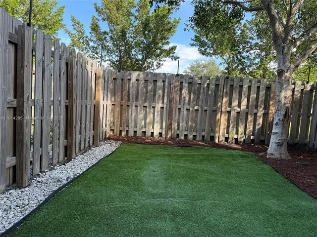 a view of a backyard with wooden fence