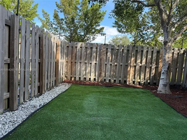 a view of a backyard with wooden fence