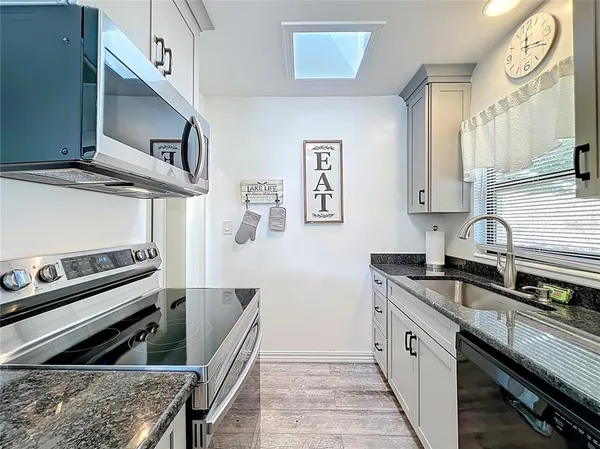 a kitchen with stainless steel appliances a refrigerator sink and white cabinets