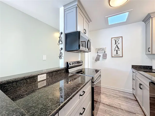 a kitchen with a table chairs and wooden floor