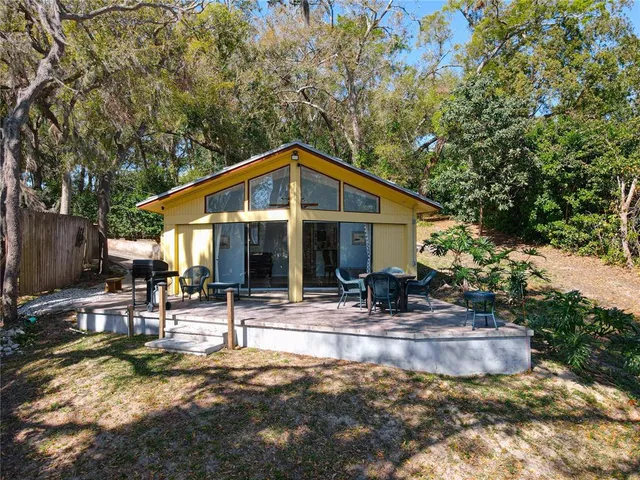 a backyard of a house with table and chairs