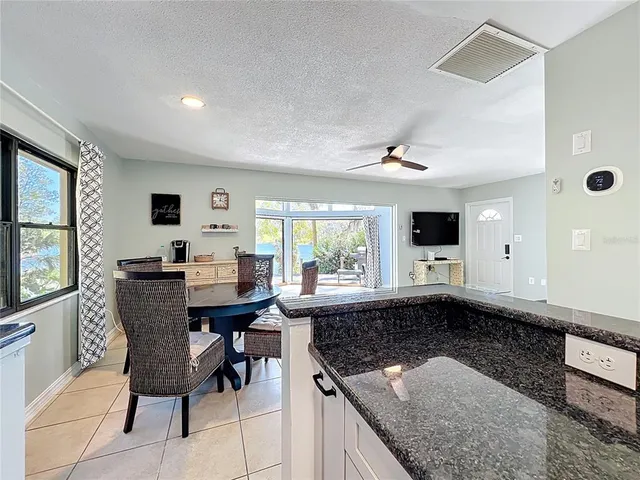 a bathroom with a granite countertop sink a toilet a mirror and shower