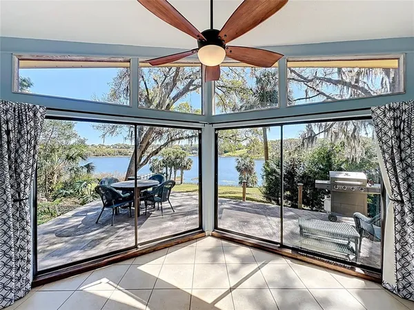 a living room with furniture a flat screen tv and a floor to ceiling window