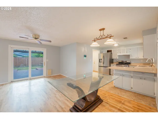 a kitchen with stainless steel appliances granite countertop a sink dishwasher and white cabinets with wooden floor
