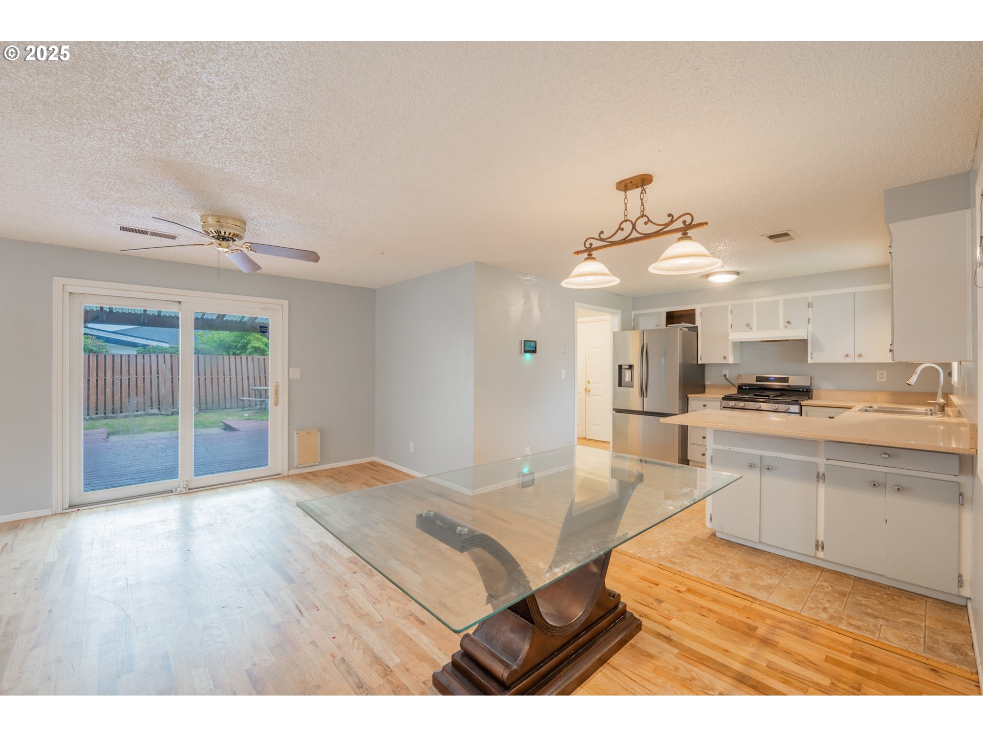 446 44th Avenue Southeast Salem, OR 97317 - Photo 3 of 37 a kitchen with stainless steel appliances granite countertop a sink dishwasher and white cabinets with wooden floor