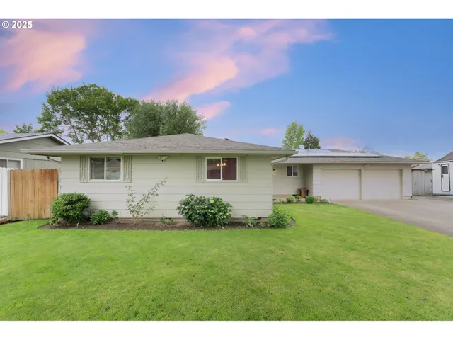 a view of a house with a yard and potted plants