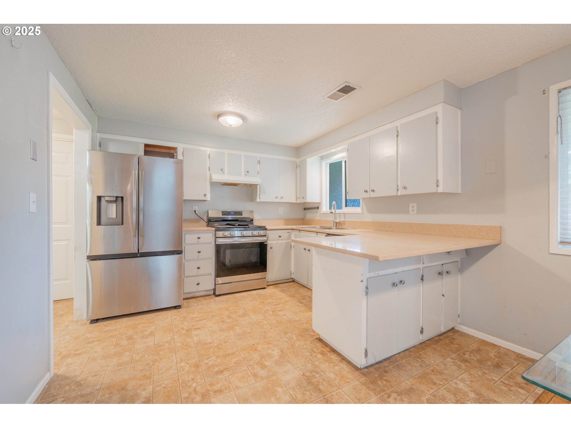 446 44th Avenue Southeast Salem, OR 97317 - Photo 10 of 37 a kitchen with stainless steel appliances white cabinets a sink a stove a refrigerator and cabinets