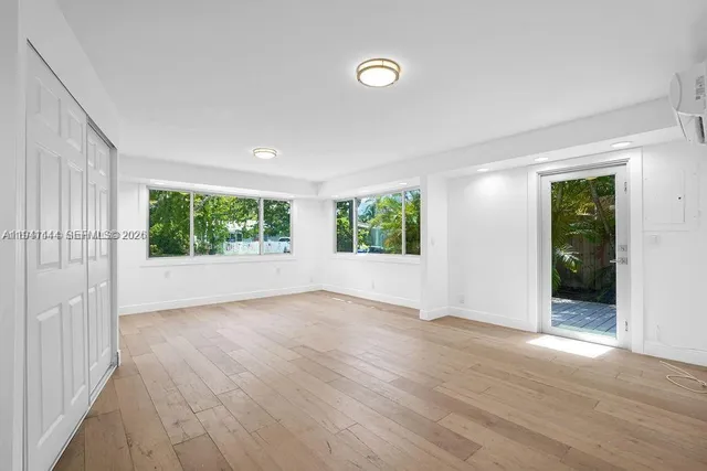 a view of a hallway with wooden floor and a window