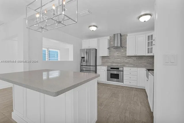 a kitchen with stainless steel appliances granite countertop a stove top oven a sink and dishwasher