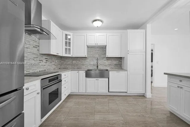 a kitchen with white cabinets and stainless steel appliances