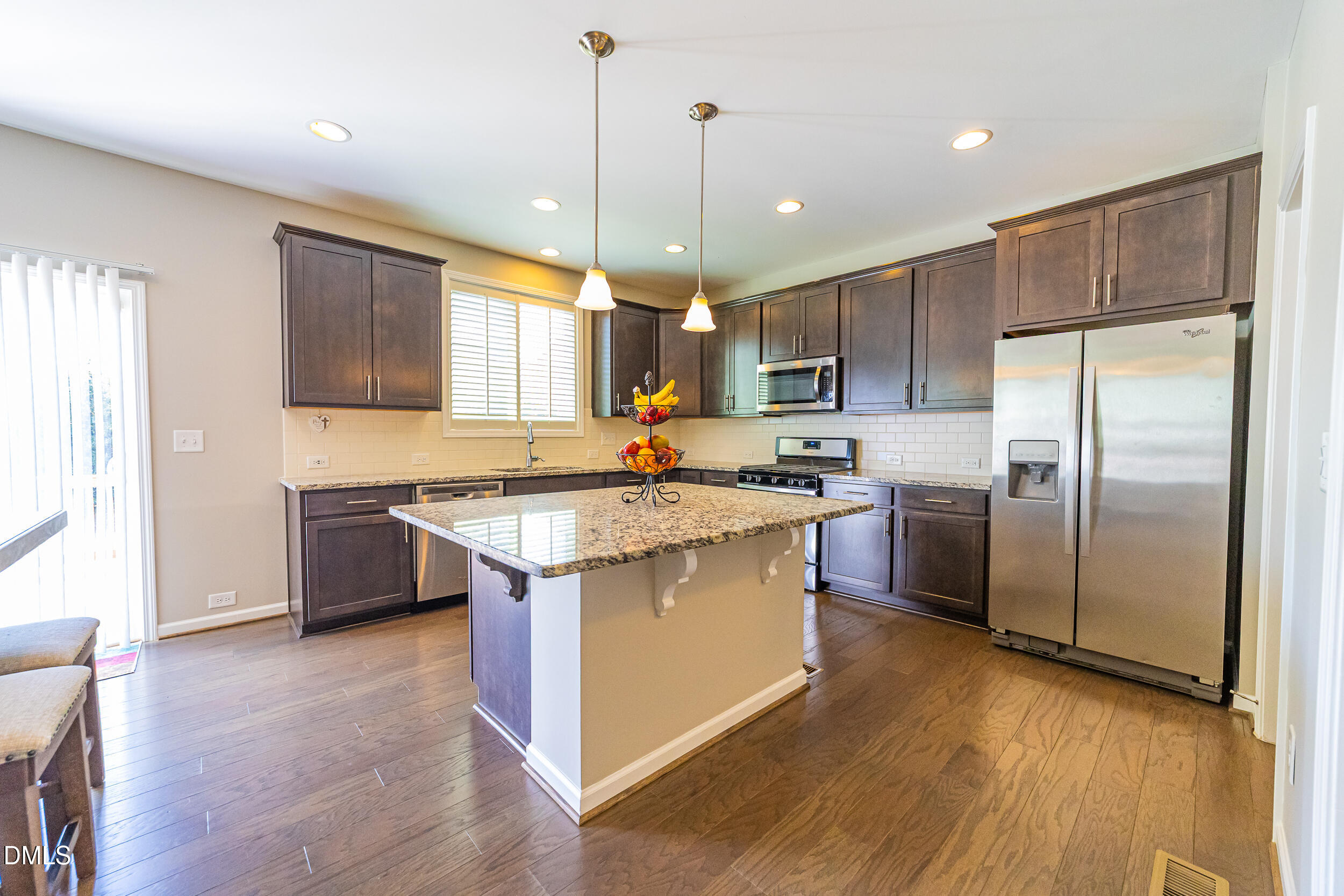 4416 Brintons Cottage Street Raleigh, NC 27616 - Photo 16 of 40 a kitchen with stainless steel appliances granite countertop a refrigerator a sink dishwasher a stove and white countertops with wooden floor
