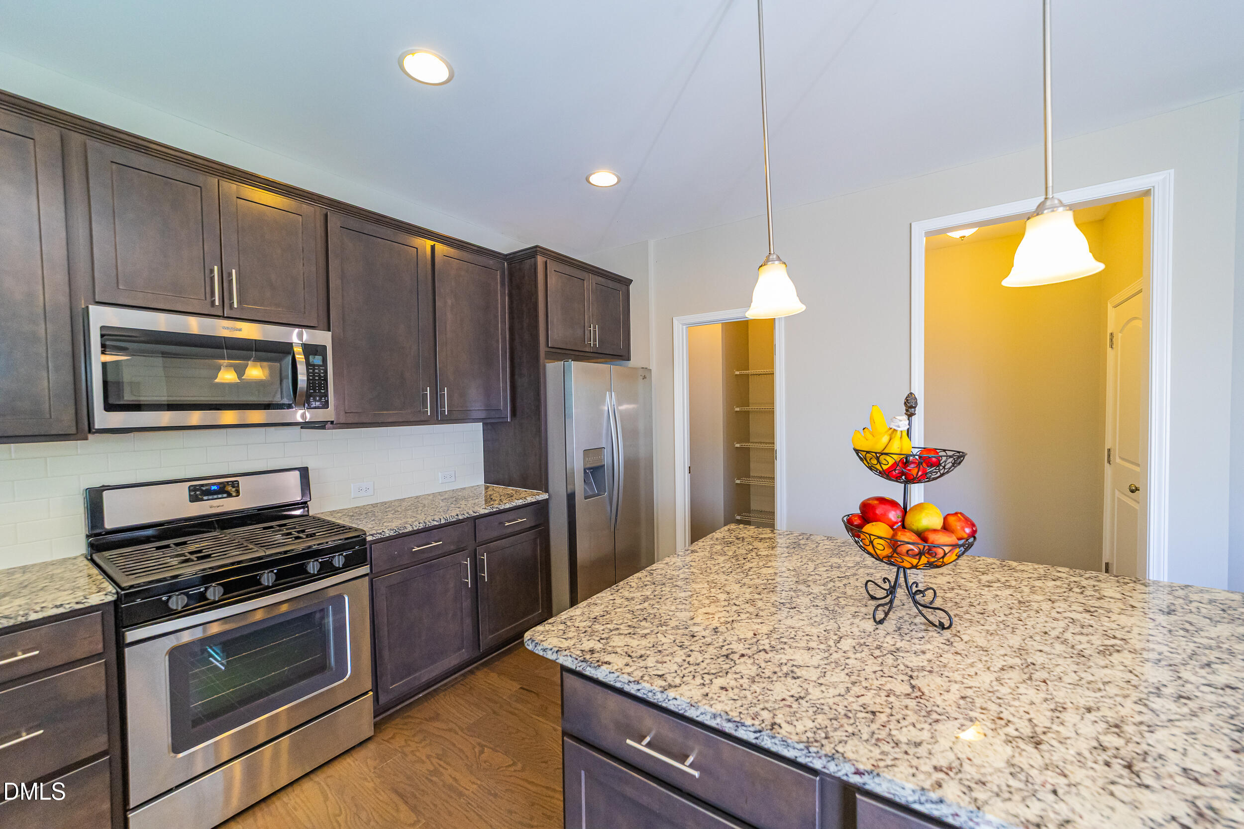 4416 Brintons Cottage Street Raleigh, NC 27616 - Photo 17 of 40 a kitchen with stainless steel appliances kitchen island granite countertop a stove refrigerator and microwave