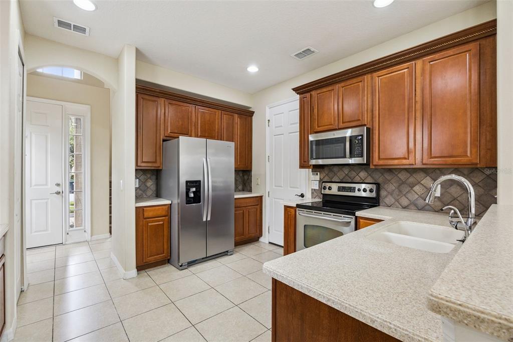 551 Terrace Spring Drive Orlando, FL 32828 - Photo 5 of 41 a kitchen with stainless steel appliances granite countertop a refrigerator stove top oven and sink