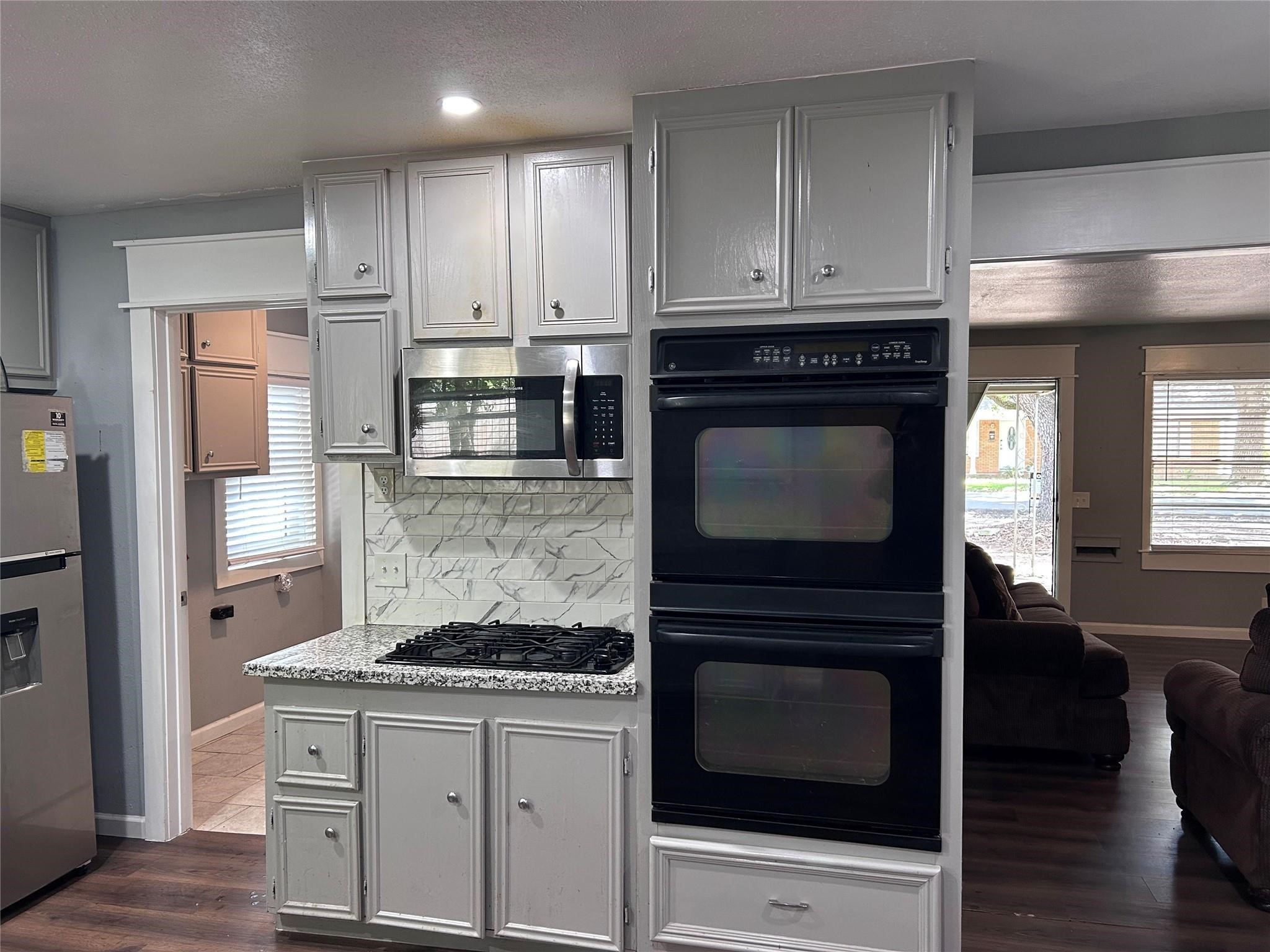 1212 Alamo Street Rosenberg, TX 77471 - Photo 8 of 34 a kitchen with granite countertop a stove top oven and cabinets