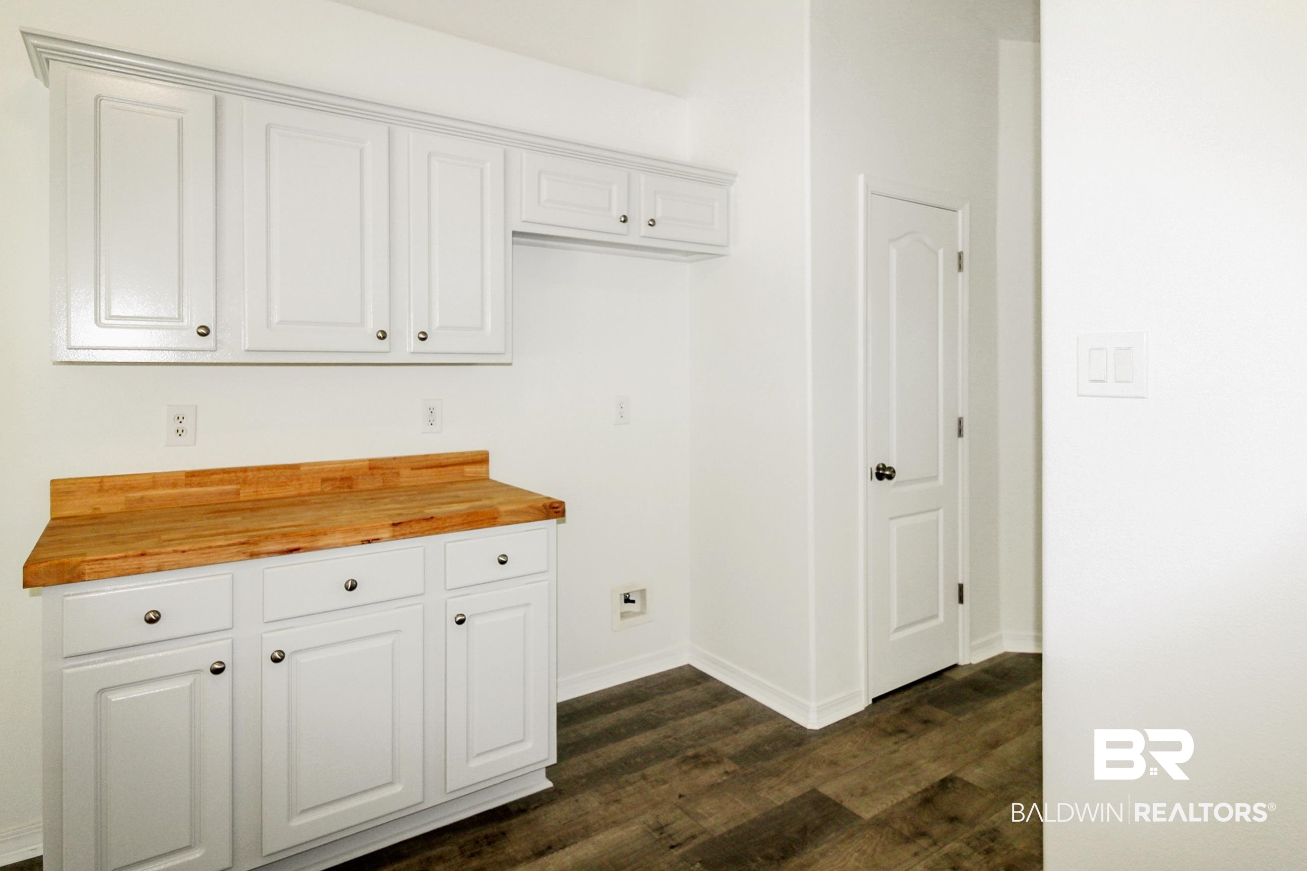 14750 Pawnee Court Foley, AL 36535 - Photo 21 of 34 Kitchen featuring butcher block countertops, dark wood-style flooring, and white cabinets