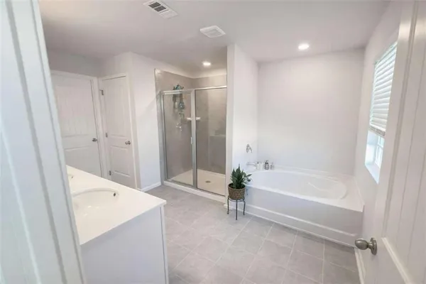 a bathroom with a tub shower and hallway
