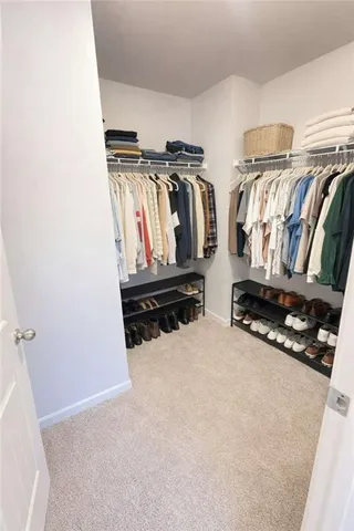 a view of walk in closet with clothes and shoes