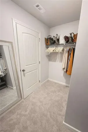 a view of walk in closet with clothes and shoes