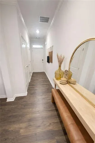 a hallway with a bed and wooden floor