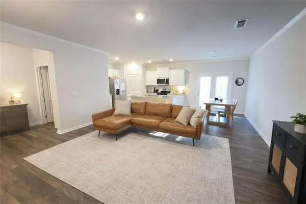 a living room with furniture and a wooden floor