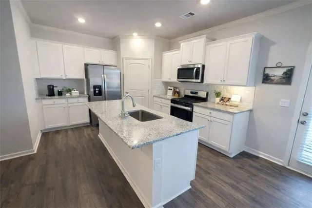 a kitchen with white cabinets and stainless steel appliances