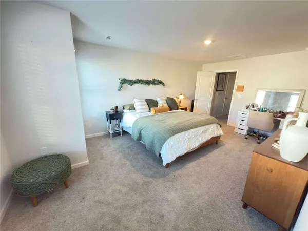 a spacious bedroom with a bed and a chair
