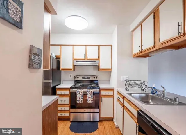 a kitchen with stainless steel appliances granite countertop a sink stove and cabinets