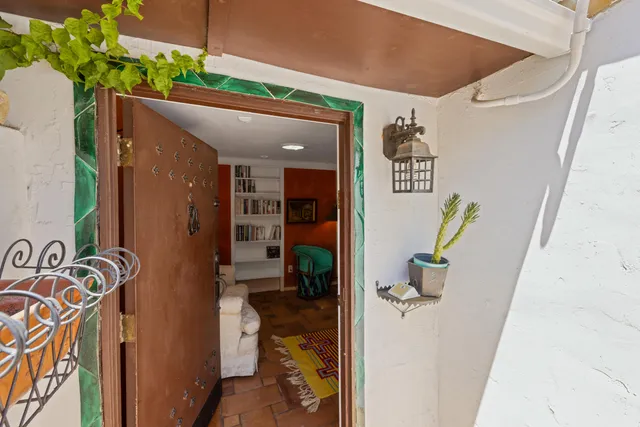 a hallway with painting on the wall and a potted plant