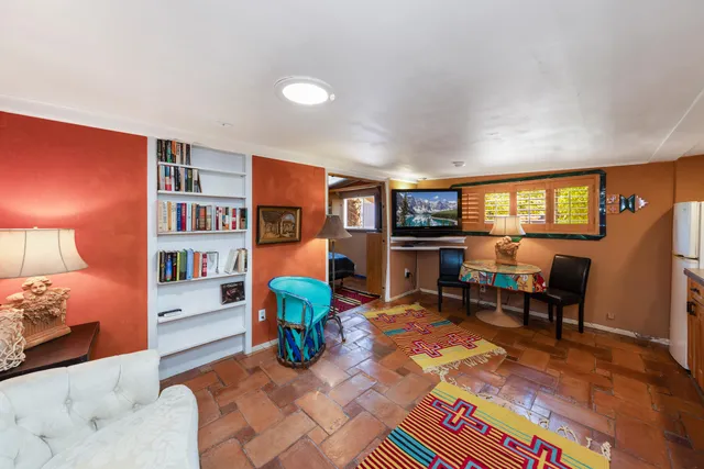 a living room with furniture a bookshelf and a window