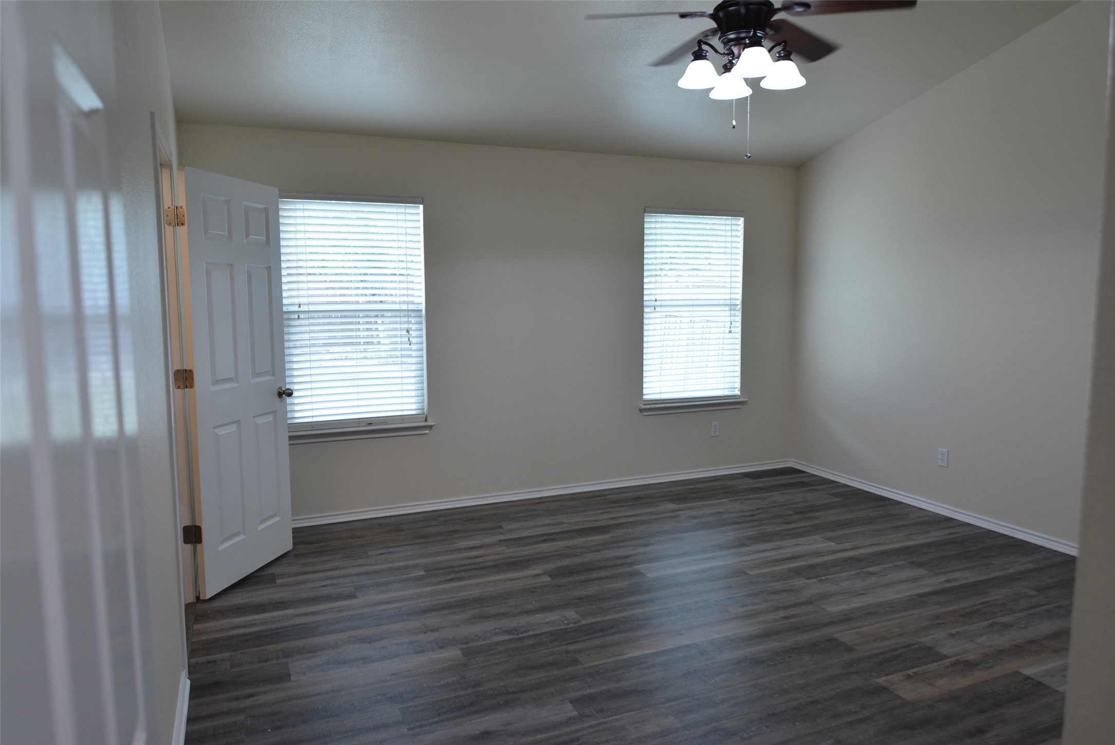 1303 Horseshoe Ranch Drive Leander, TX 78641 - Photo 12 of 26 Well-lit interior space features sleek wood flooring and two windows with blinds.
