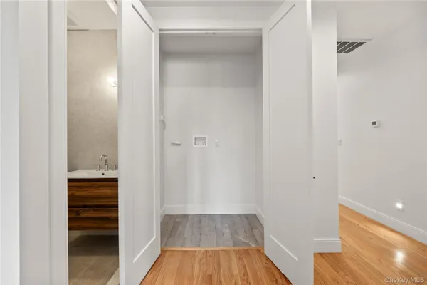 a view of a hallway with wooden floor and closet