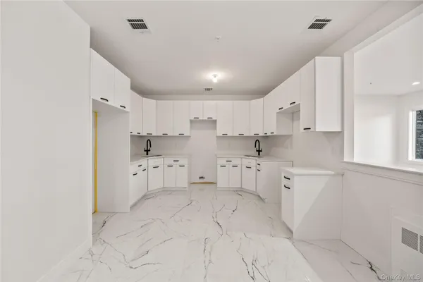 a kitchen with white cabinets and white appliances