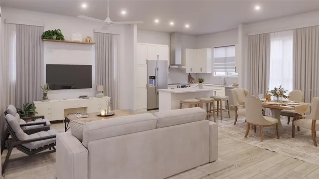 a living room with furniture a flat screen tv and kitchen view