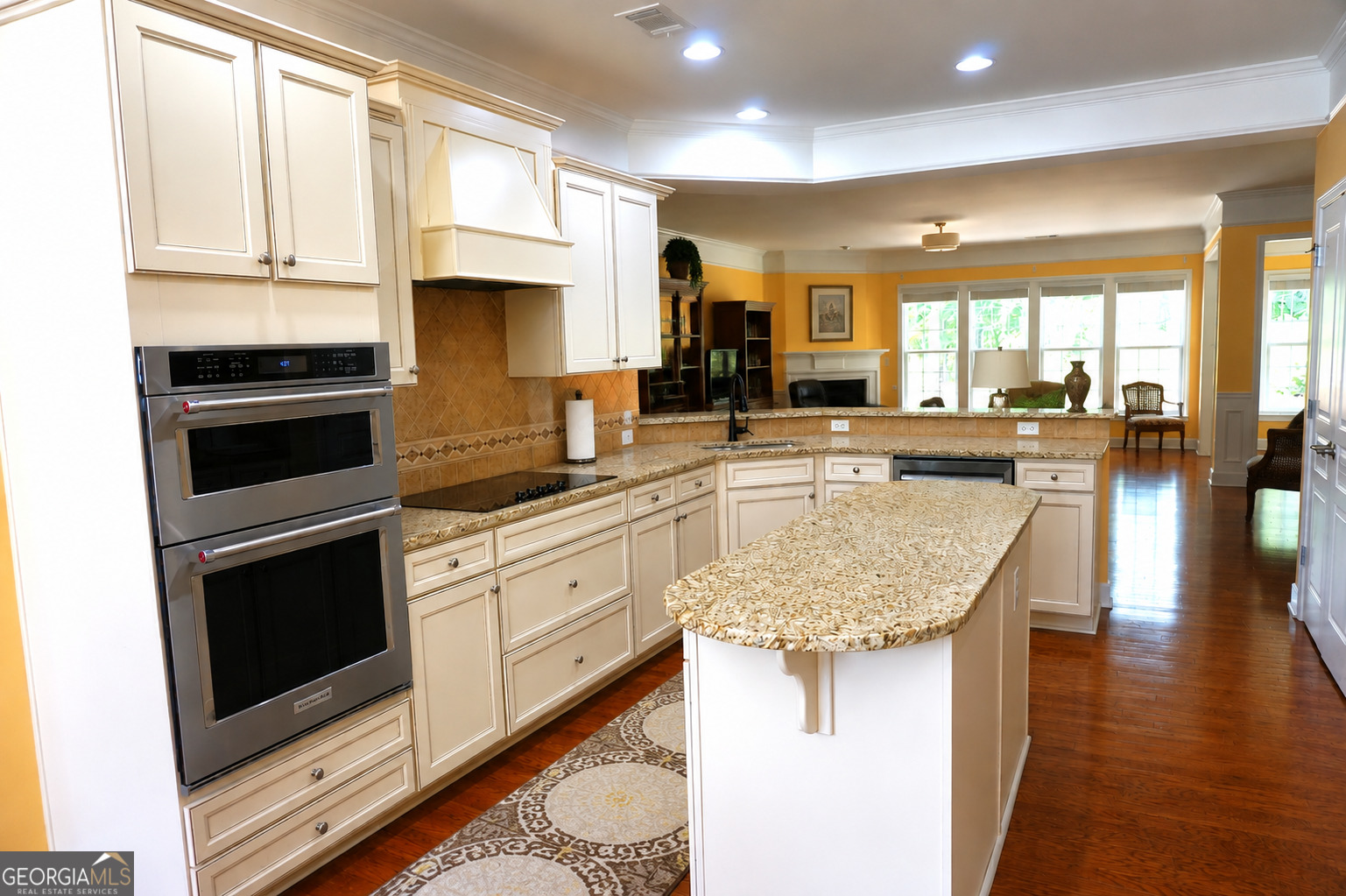 1211 Water Front Road Greensboro, GA 30642 - Photo 8 of 40 a kitchen with kitchen island granite countertop a stove a sink and white cabinets with wooden floor