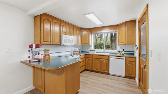 a kitchen with kitchen island granite countertop wooden floors granite top and stainless steel appliances