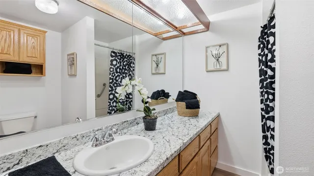 a bathroom with a granite countertop sink mirror and vanity