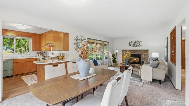 a living room with furniture a fireplace and a large window