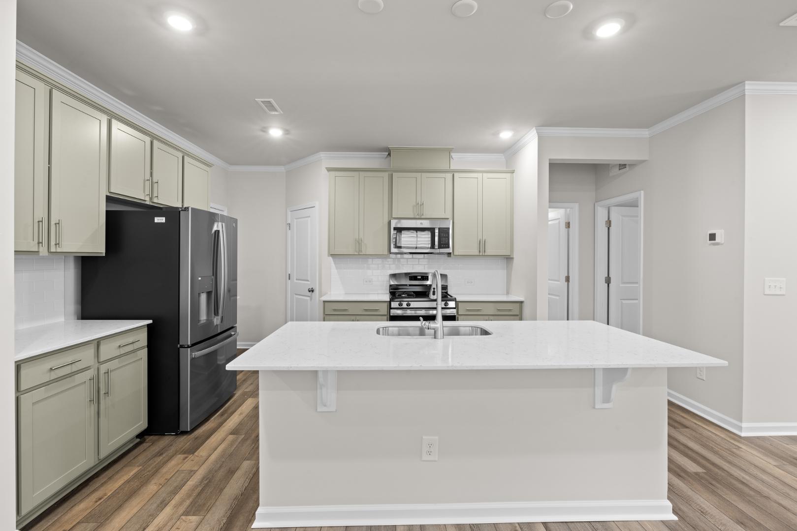 a kitchen with kitchen island a counter top space cabinets stainless steel appliances and cabinets